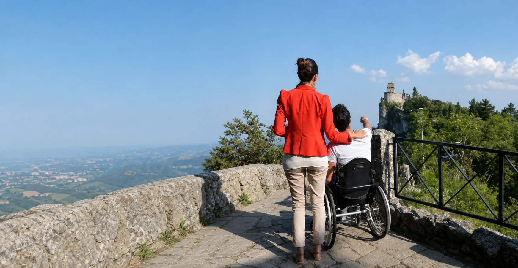 Una donna e un uomo in carrozzina insieme su un belvedere di San Marino